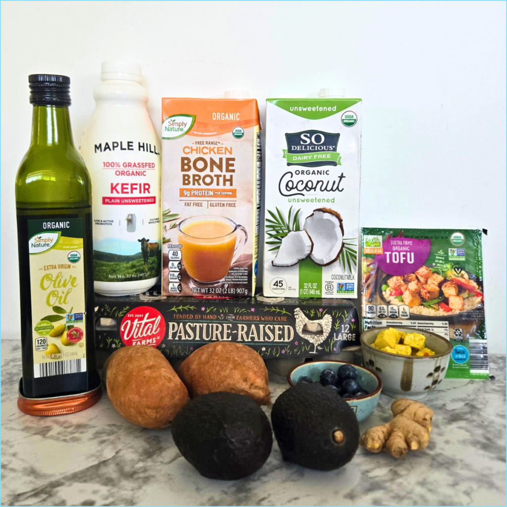 Real grocery store staples for The Embrobi Shop, including kefir, olive oil, bone broth, coconut milk, tofu, eggs, blueberries, avocados, sweet potatoes, and ginger.